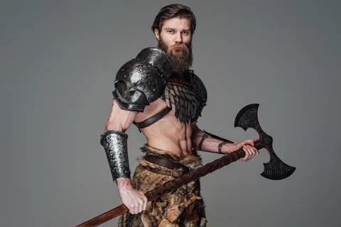 Barbaric warrior from the north posing in studio with a huge axe 库存照片