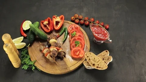 Barbecue and vegetables on a black table Top. Slide. Slow motion Stock Footage 81713214