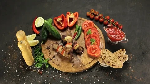 Barbecue and vegetables on a black table Top. Slide. Slow motion Stock Footage 81713266