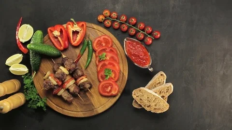 Barbecue and vegetables on a black table Top. Slide. Slow motion Stock Footage 81713345