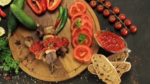 Barbecue and vegetables on a black table Top. Slide. Slow motion Stock Footage 81713358