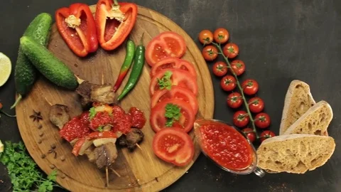 Barbecue and vegetables on a black table Top. Slide. Slow motion Stock Footage 81713362