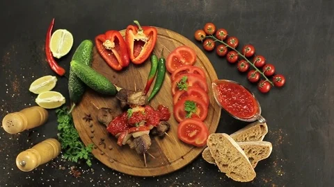 Barbecue and vegetables on a black table Top. Slide. Slow motion Stock Footage 81713383