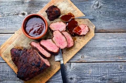 Barbecue dry aged wagyu tri tip steak with BBQ sauce as dip as top view on a  Stock Photos