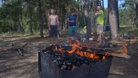 Barbecue. fire is burning. people in the background. cooking on fire. Video stock 113281830