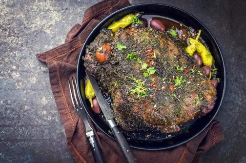 Barbecue marinated lamb roast with peperoni and olives as close-up in a bowl Stock Photos