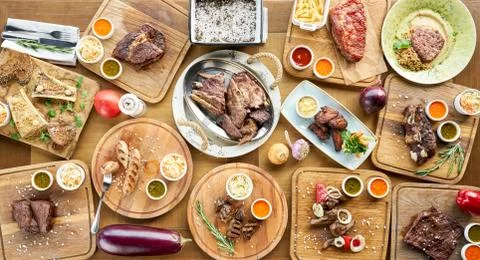 Barbecue restaurant menu. Many different food on the table. Dinner party or Stock Photos