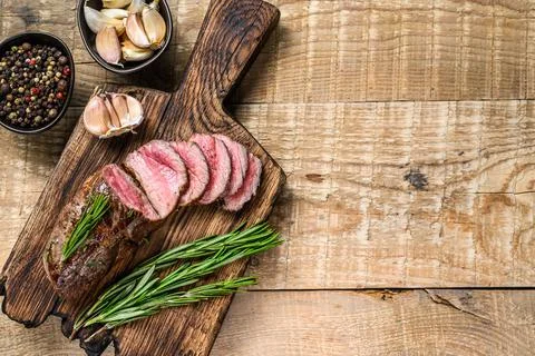 Barbecue Sliced veal tenderloin meat steak. wooden background. Top view. Copy Stock Photos