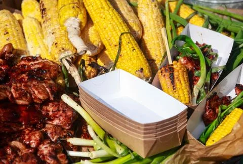 Barbecue spread corn on the cob, steak fillet and chicken kebabs with corn. Stock Photos