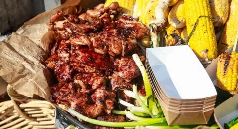 Barbecue spread corn on the cob, steak fillet and chicken kebabs with corn. Stock Photos