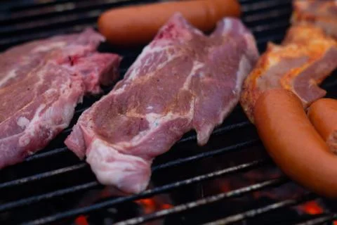 Barbecuing meat on a grill Stock Photos