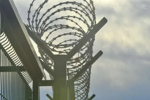 Barbed razor wire on a high-security building. Barbed wire and hard wire fence 스톡 사진