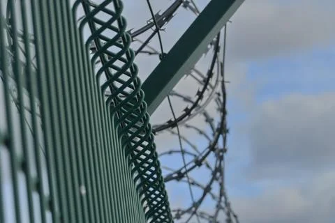 Barbed razor wire on a high-security building. Barbed wire and hard wire fence Foto stock