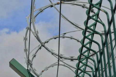 Barbed razor wire on a high-security building. Barbed wire and heavy wire Fotos de archivo
