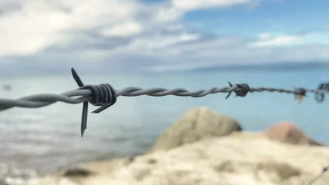 Barbed wire against the background of the sea. closed fenced area Stock Footage 265867910