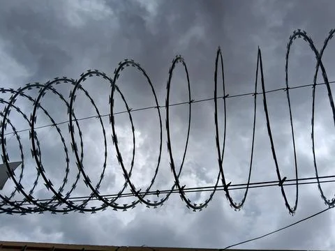 Barbed wire against cloudy sky Stock Photos