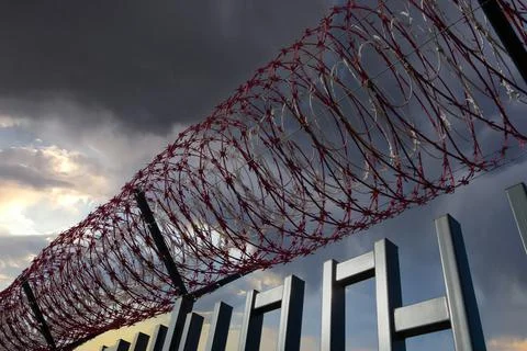 Barbed wire and cloudy sky - fence. Stock-Fotos