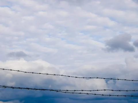 Barbed wire and dark clouds sky backgrounds Stock Photos