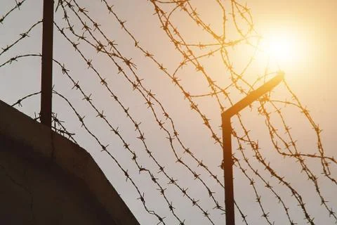 Barbed wire and light as a hope. Freedom, prison and hope concept. Stock Photos