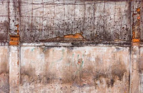 Barbed wire on background of old dirty concrete painted cracked wall. Copy space Stock Photos