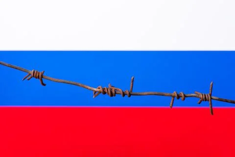 Barbed wire on a background of Russian flag Stock Photos