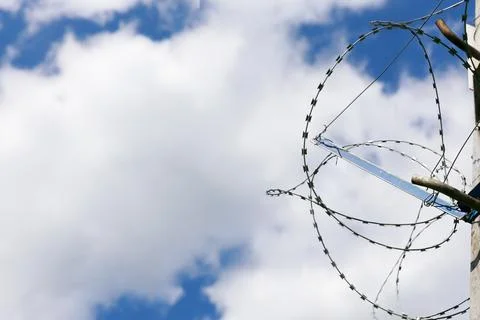 Barbed wire on blue sky background. Concept of boundary, prison or military base Stock Photos