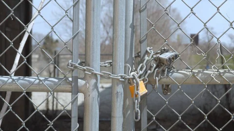 Barbed wire chain link fence on a on a sunny day in early spring. 4k60p Stock Footage 130142862