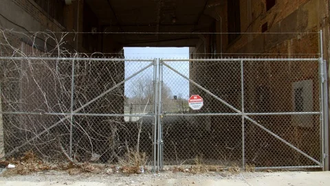 Barbed wire chain link fence is closed on a sunny day in early spring. 4k60p Stock Footage 130143413