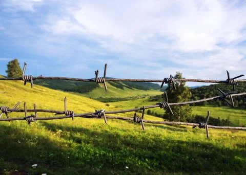 Barbed wire closes access to a beautiful landscape. Stock-Fotos