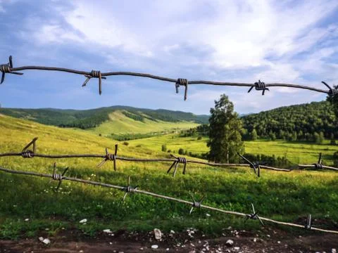 Barbed wire closes access to a beautiful landscape. Photos
