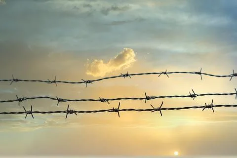 Barbed wire with cloudy sky in the background Stock Photos