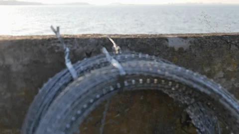 Barbed wire on a concrete wall with the river on the background Stock-Footage 239457999