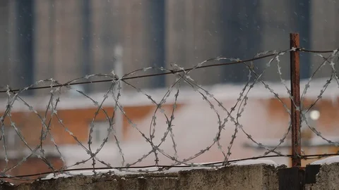 Barbed wire during snowfall. Smoke and emissions of old factory in a background Stock Footage 121369113