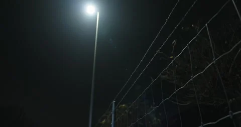 A barbed wire fence at a border at night Stockbeeldmateriaal 294160503
