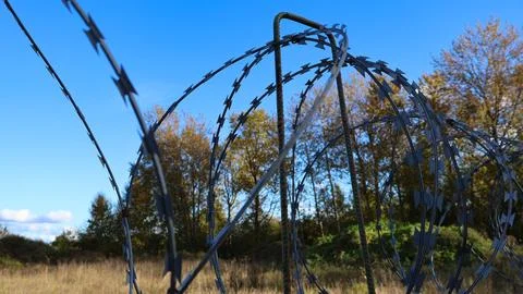 Barbed wire fence creating a restrictive barrier Stock Photos
