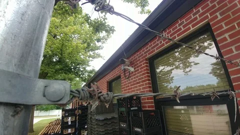 Barbed Wire Fence with Security Camera on Building Stock Footage 113407011