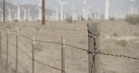 Barbed Wire Fence with Windmills in the Background Stock Footage 89942493