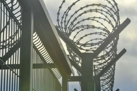Barbed wire on a high-security building. Barbed wire and solid wire fencing Fotos de archivo