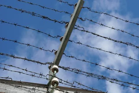 Barbed wire with high voltage on the prison fence Stock Photos