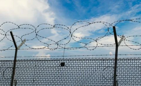 Barbed wire isolated on blue cloud background Stock Photos