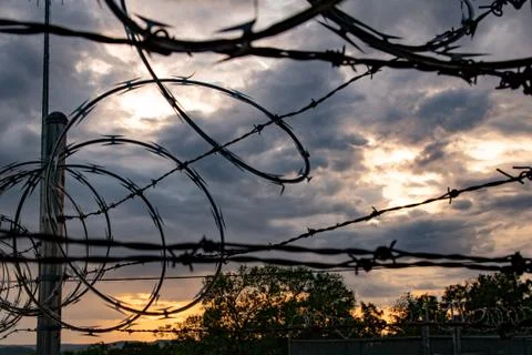 Barbed Wire Loops During Cloudy Sunset Stock Photos