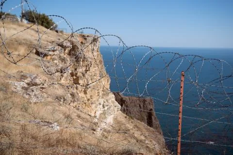 Barbed wire netting on coast Stock Photos