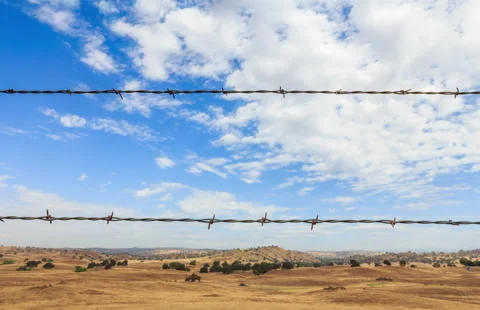 Barbed Wire Over Field With Clouds Timelapse Stock Footage 235491491