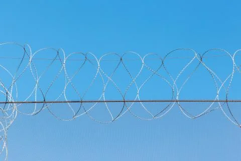 Barbed wire in the prison in the background of the blue sky Stock Photos