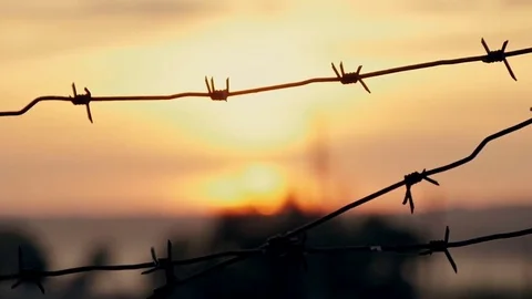 Barbed wire prison sunset orange Stock Footage