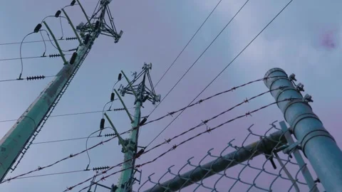 Barbed wire security fence protecting electrical utility towers Stockbeeldmateriaal 340006020