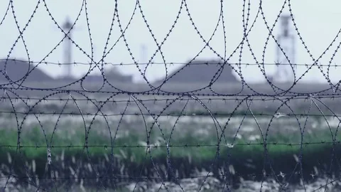 Barbed wire. Selective focus of barbed wire at airport with radar antennas in Stock Footage 75848591