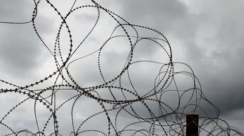 Barbed wire  trembling in the wind on the  dark stormy clouds background Stock Footage 48003258