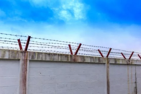 Barbed wire wall on blue sky Stock Photos