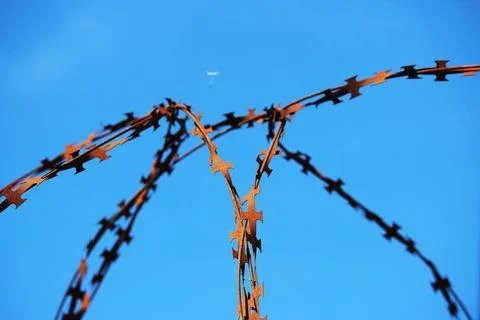 Barbed wire on the wall of a closed enterprise and a free parachute from a... Stock Photos